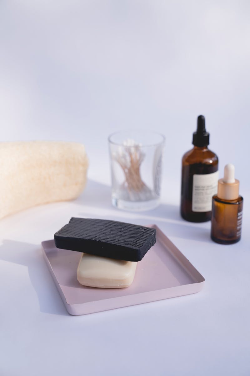 Aesthetic arrangement of skincare essentials including soaps and serums on a tray.